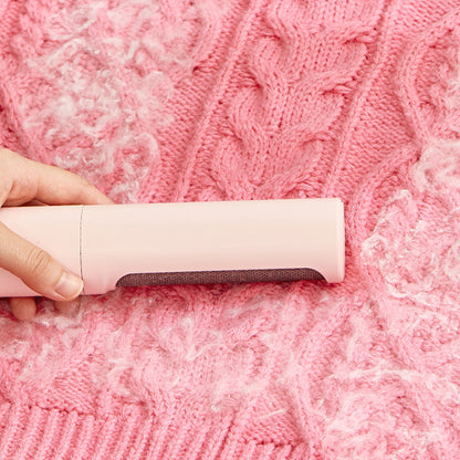 Person using a pink lint roller on a pink textured fabric