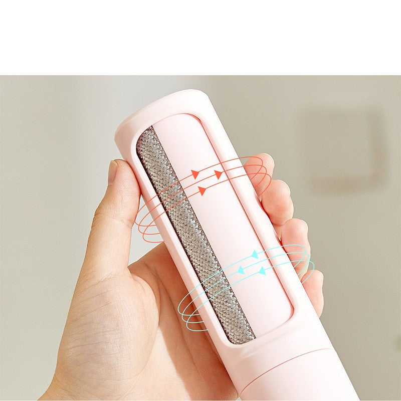 Pink pet hair remover held in a hand against a neutral background