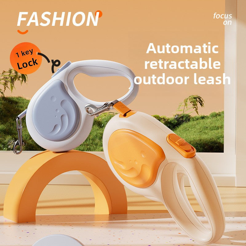 Automatic retractable outdoor leash with key lock feature on a wooden surface.