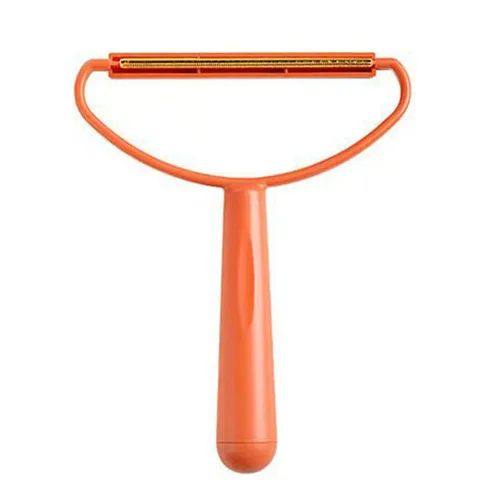 Orange pet grooming brush on a white background