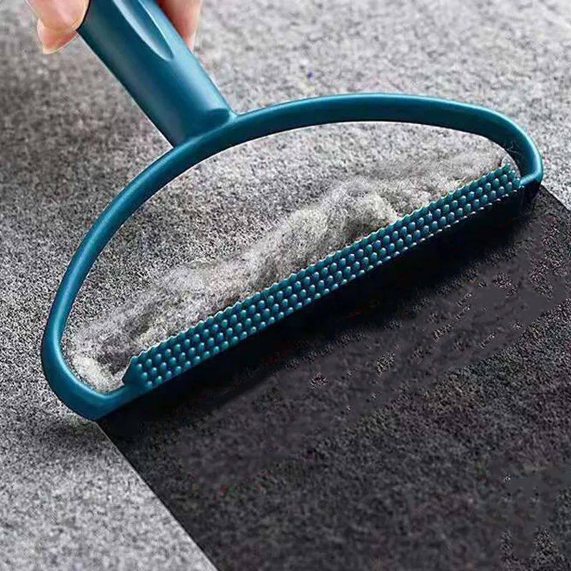 Blue pet grooming brush being used on a textured surface